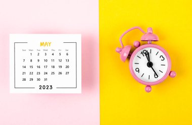 May 2023 Monthly calendar for 2023 year with pink colour alarm clock on beautiful background.