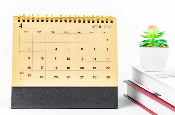 stock image April 2023 Monthly desk calendar for 2023 year with the books on white background.