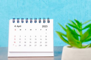 Nisan 2023 Aylık masa takvimi mavi arka planda bitki saksısı ile 2023 yılı.