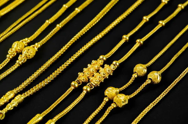 Blurred gold jewelry necklace chains on black for background, panel gold for shop jewelry.