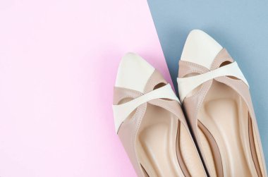 Pembe arka plandaki kadınlar için yakın plan kahverengi alçak topuklu ayakkabılar.