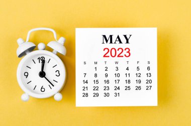 2023 Mayıs takvimine göre alarm saati sarı arka planda..