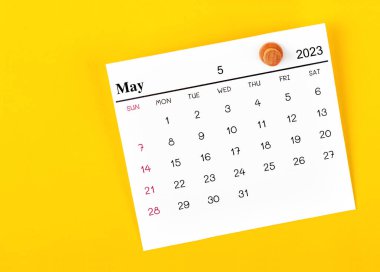 Mayıs 2023 takvim ve ahşap pimi sarı arkaplanda.