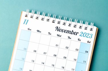 Mavi arkaplanda, organizatörün planlayıp hatırlatması için Kasım 2023 takvim masası.