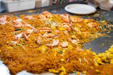 'Pad Thai', is a street food meal throughout Thailand. Here the ingredients are being stir fried in a large wok or metal hot plate.