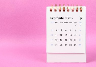 2023 Eylül 'ünün masa takvimi pembe arka planda..