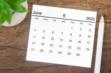 2023 Haziran ayı takvimi. Ahşap arka planda bir kalemle 2023 yılı..