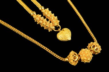 Siyah arkaplanda altın bir kolye.