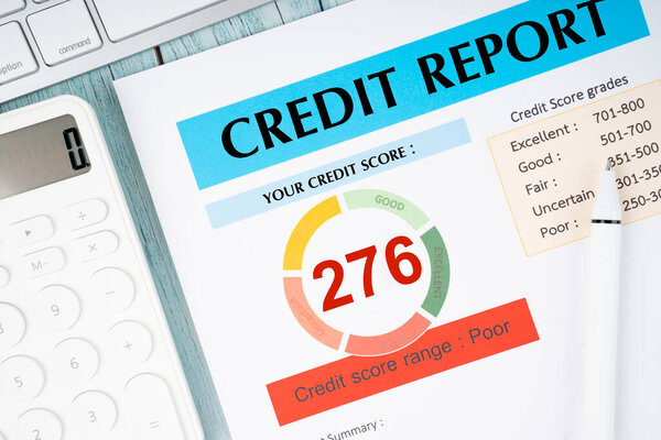 Credit score report document and pen with calculator on the desk.