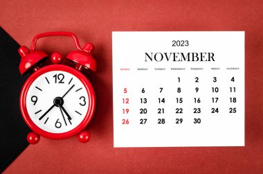 Kasım 2023 Aylık takvim yılı kırmızı ve siyah arkaplan alarm saati.