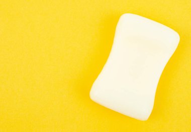 Sarı zemin üzerinde doğal beyaz şifalı sabun çubukları ve kopyalama alanı.