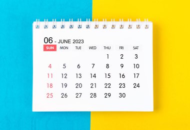 June 2023 Monthly desk calendar for 2023 year on blue and yellow background.