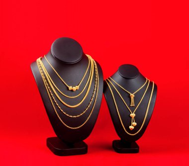 Kırmızı ve siyah gerdanlıklarda altın kolyeler..