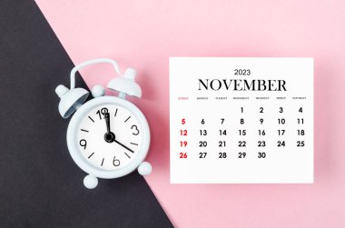 Kasım 2023 Aylık takvim yılı Pembe ve siyah arkaplan alarm saati.