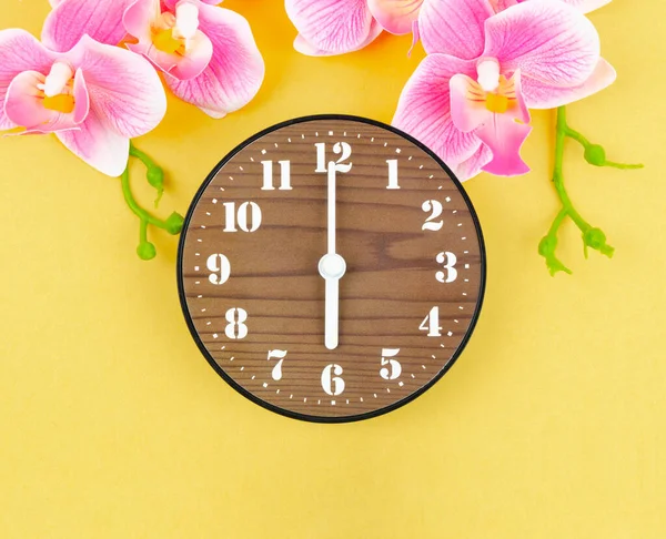 Reloj Despertador Madera Con Orquídea Color Pico Sobre Fondo Amarillo —  Fotos de Stock