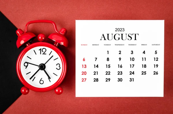 stock image August 2023 Monthly calendar year with alarm clock on red and black background.