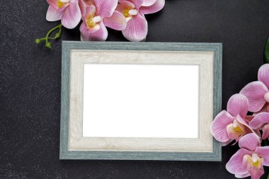 Eski siyah ahşap arka planda pembe renkli orkide ile boş ahşap fotoğraf çerçevesi, kırpma yolunu kaydet. Düz yatıyordu.
