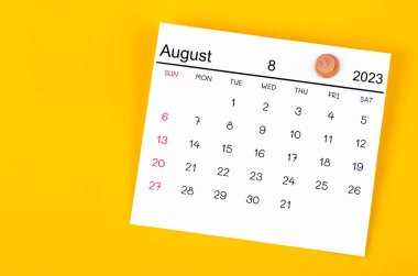 Ağustos 2023 ve sarı arkaplanda tahta raptiye.