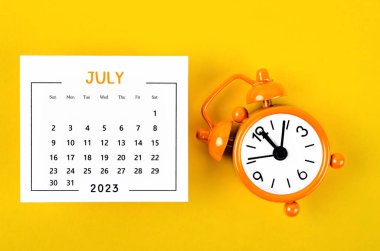 2023 yılı Temmuz ayı takvimi. Sarı zemin üzerinde siyah alarm saati var..