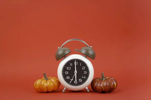 赤の背景に秋のカボチャとヴィンテージ目覚まし時計 — ストック写真
