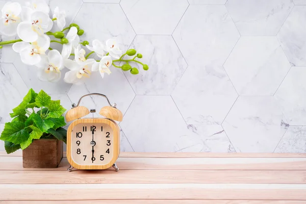 木製の目覚まし時計とあなたのデザインのためのコピースペースと木製の床に白い蘭 — ストック写真