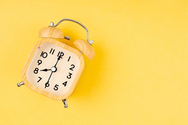 黄色の背景にレトロな木製の目覚まし時計 — ストック写真