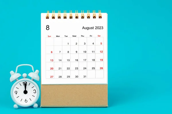 2023年8月2023年月度工作台日历和蓝色背景闹钟 — 图库照片