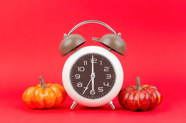 赤の背景に秋のカボチャとヴィンテージ目覚まし時計 — ストック写真