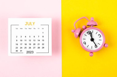 July 2023 Monthly calendar for 2023 year with pink colour alarm clock on beautiful background.