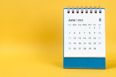 June 2023 desk calendar on yellow color background.