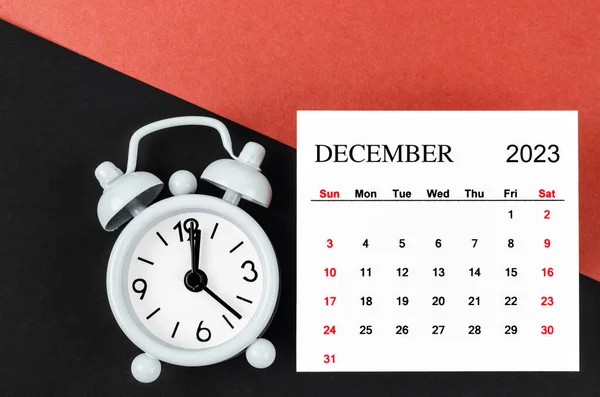 2023年12月赤と黒の背景に目覚まし時計と毎月の暦年 — ストック写真
