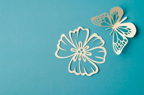 绿色纸板背景上的白纸蝴蝶和花朵雕刻品 — 图库照片