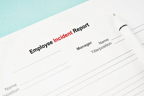 Template of an Employee incident report form document and and pen on blue background.