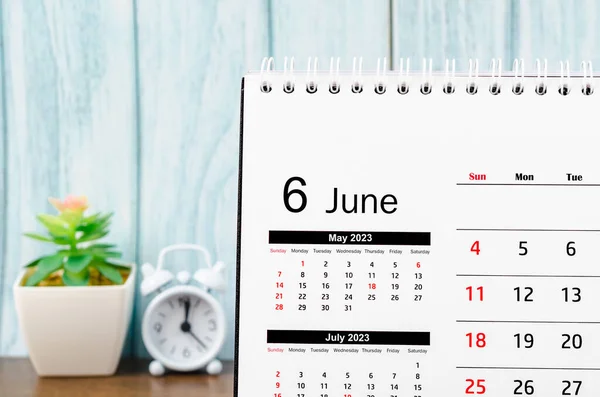 stock image June 2023 Monthly desk calendar for 2023 year with alarm clock on blue wooden background.