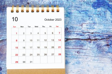 2023 Ekim ayının masa takvimi eski mavi ahşap arka planda 2023 yılı için.