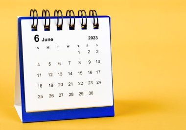 June 2023 desk calendar on yellow color background.