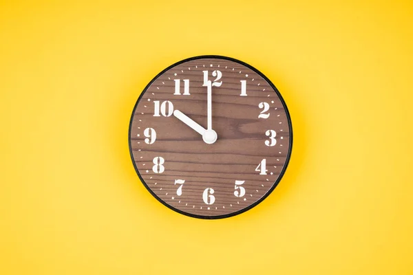 黄色の背景に10時位置にレトロな木製の時計 — ストック写真