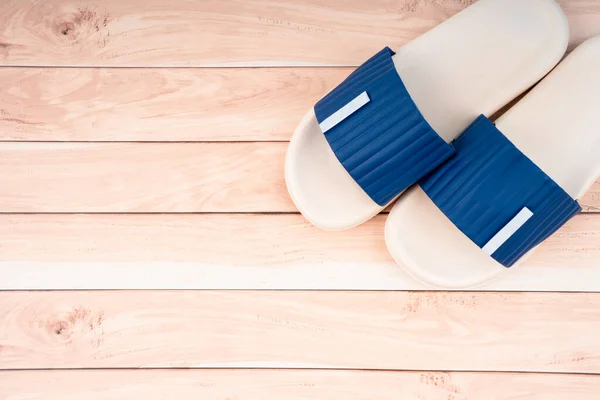 白色和蓝色的橡胶拖鞋在木制地板上 有复制空间 暑假的概念 — 图库照片