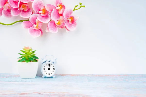 木製の床の上の目覚まし時計とピンクの色の蘭あなたのデザインのためのコピースペース — ストック写真