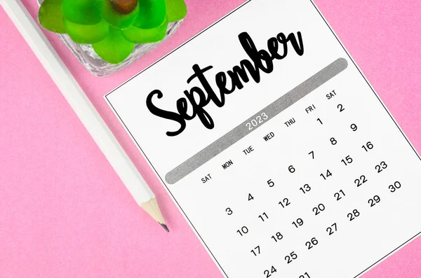 stock image September 2023 Monthly calendar for 2023 year with pencil on pink background.