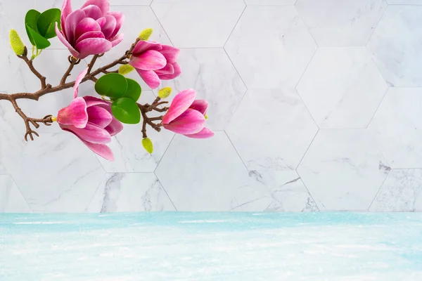 青い木製の床と大理石の背景に美しいピンクのマグノリアの花あなたのデザインのためのコピースペース — ストック写真