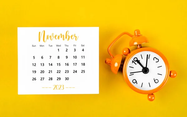 2023 Kasım Ayının Takvimi Sarı Arka Planda Siyah Alarm Saati — Stok fotoğraf