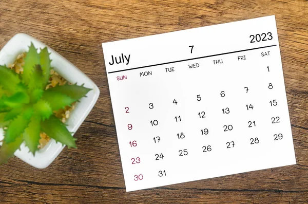 stock image July 2023 Monthly calendar for 2023 year on wooden background.