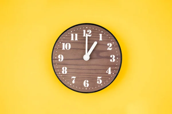 黄色の背景に1時位置にレトロな木製の時計 — ストック写真