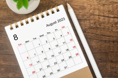 2023 Ağustosunun masa takvimi. Ahşap arka planda kalem var..