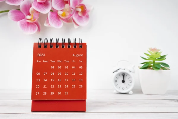 Red calendar August 2023. Desk calendar for year 2023 and pink color orchid.