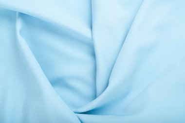 Light blue crumpled fabric texture background. Close up.