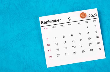 Eylül 2023 ve ahşap raptiye mavi arkaplanda.