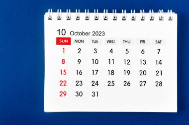 Koyu mavi arka planda 2023 yılı için Ekim 2023 aylık masa takvimi.