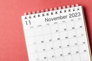 Kırmızı arkaplanda, organizatörün planlayıp hatırlatması için Kasım 2023 takvim masası.